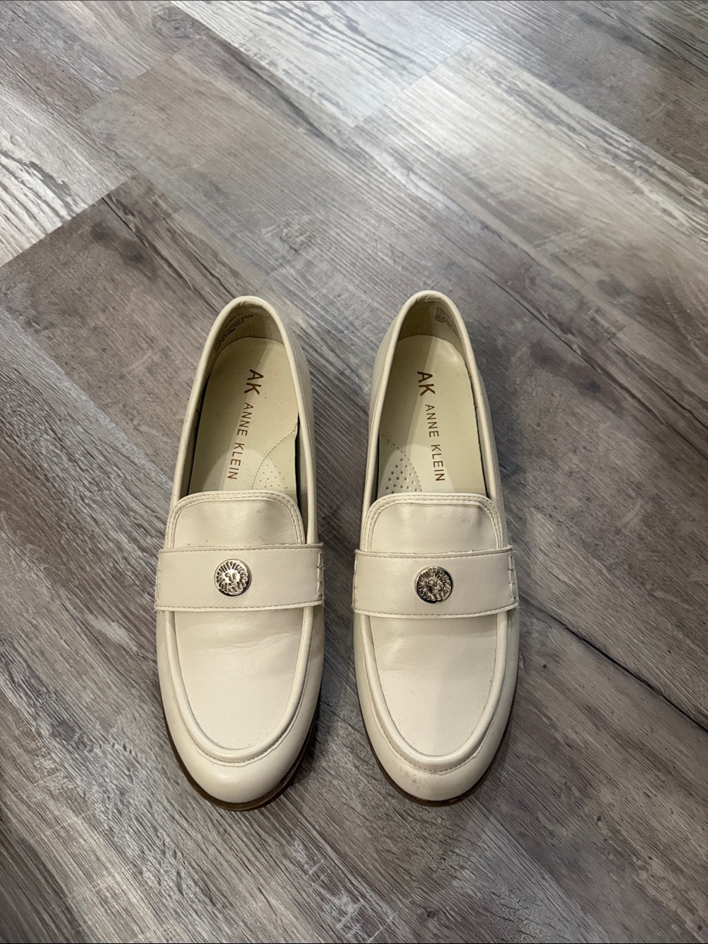 Anne Klein Ivory Leather Slip-On Loafers with Metal Emblem